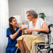 caretaker feeding senior woman patient