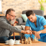 senior and caretaker playing chess